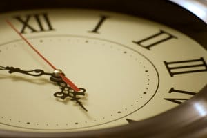 Close-up of a clock face with Roman numerals and a red second hand, symbolizing time-related delays in mesothelioma litigation.