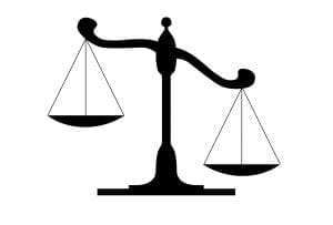 Scales of Justice Illustration – Ohio Asbestos Bill - Ferraro Law Firm Black silhouette illustration of uneven scales of justice, symbolizing fairness concerns tied to asbestos lawsuit legislation in Ohio.