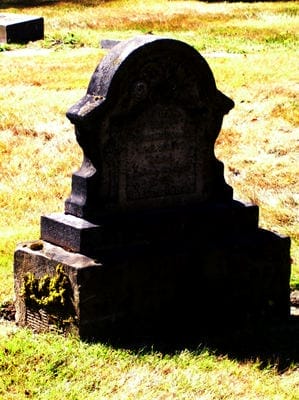 Weathered Gravestone in Cemetery – Wrongful Death Case - Ferraro Law Firm Old gravestone in a cemetery surrounded by grass, symbolizing wrongful death claims such as Riggs v. Georgia-Pacific.