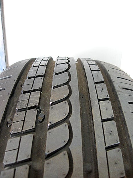 Close-up view of a vehicle tire tread showing wear and potential defects, symbolizing tire-related safety hazards.