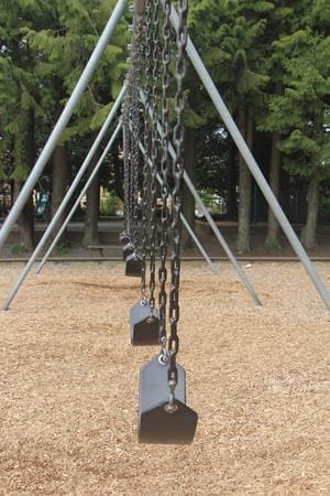 Row of empty swings on a playground, symbolizing loss and damages in asbestos exposure cases like Soto v. Bargwarner Morse Tec Inc.