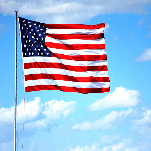 American flag waving against a bright blue sky, representing justice and advocacy for victims of Camp Lejeune water contamination.
