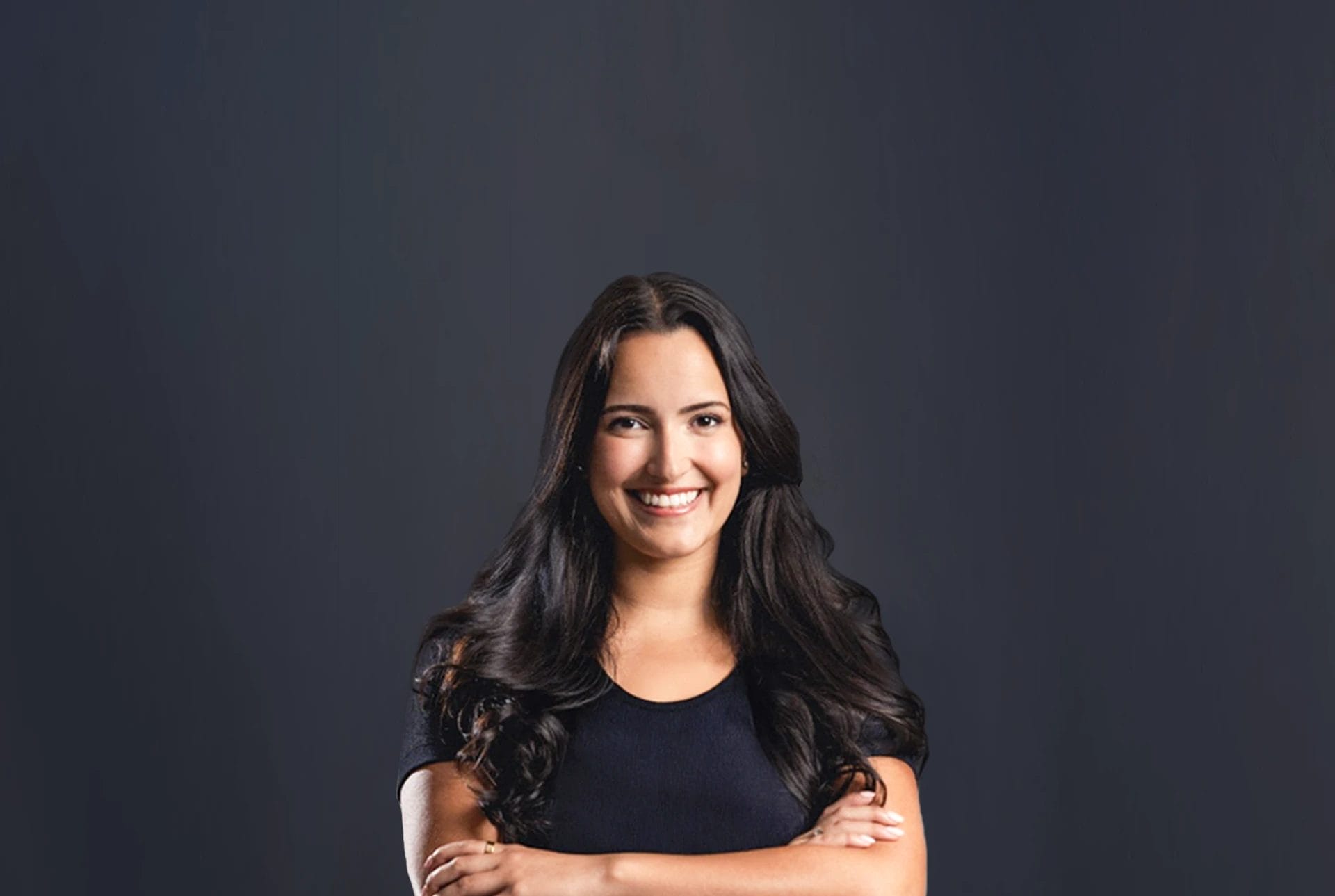 Smiling attorney standing with arms crossed against a dark background, symbolizing courtroom confidence and skill in opening statements.